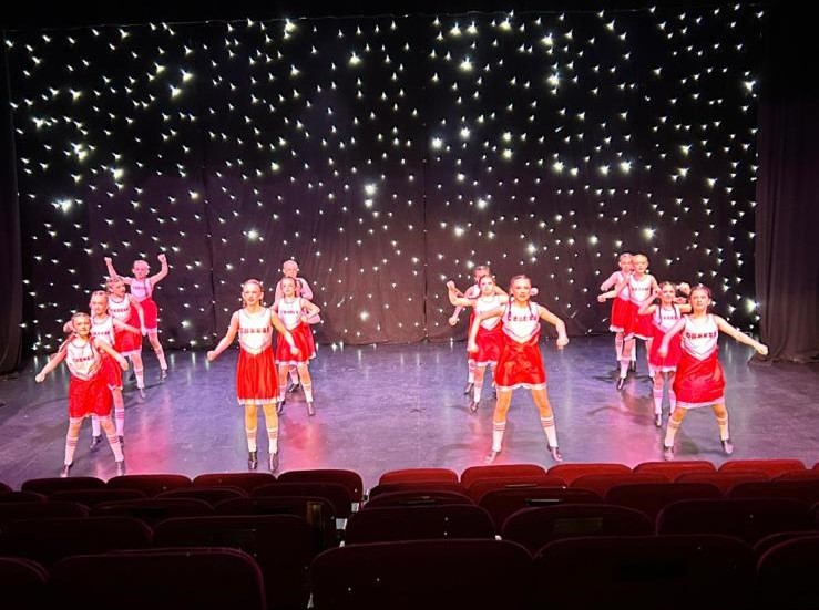 Group performing acro lifts during the dance school showcase